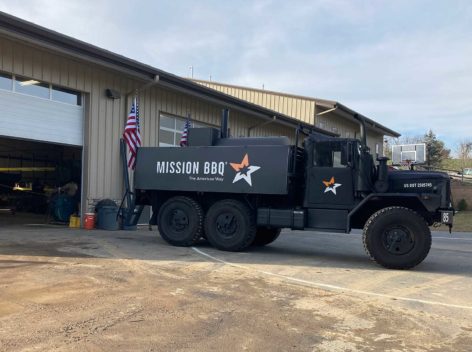 Large grey military truck with Mission BBQ logo